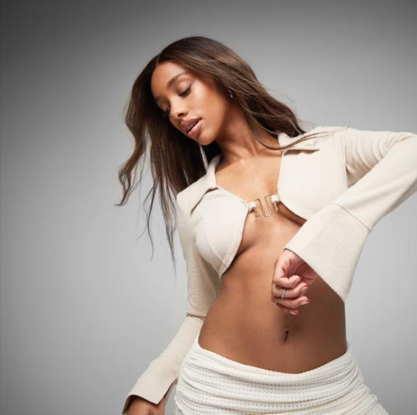 long sleeve going out tops: A model posing in a cream coloured long sleeve crop top