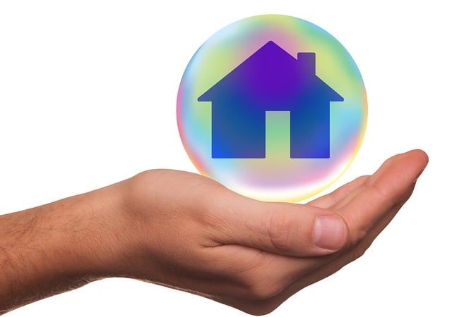 Colourful house in a bubble floating on a hand