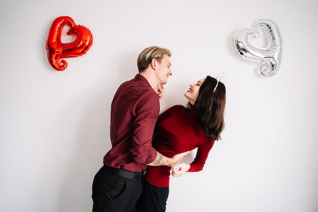 Valentine's Day outfit ideas: A couple embracing between two heart balloons