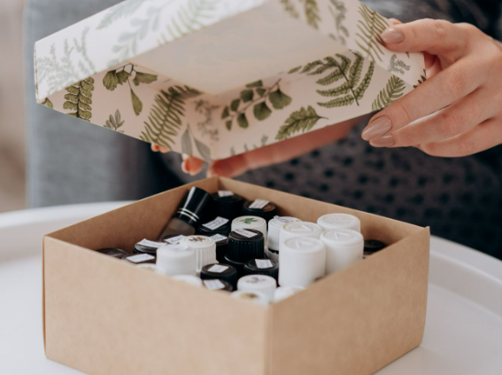 Two hands opening a NOTINO discovery box with perfume samples.