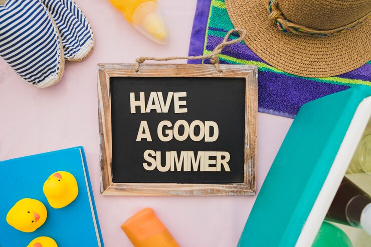 Image: Things to do this summer holidays: A black sign with a white caption with summer items around it. Things to do this summer holidays: A black sign with a white caption with summer items around it.