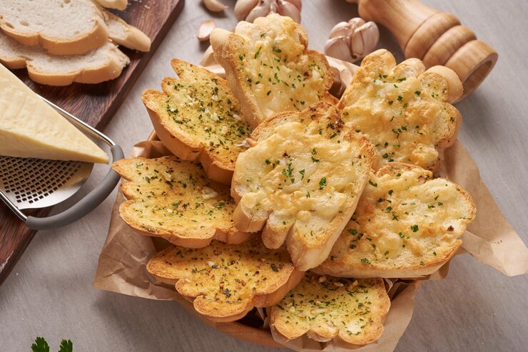 Prosecco cocktail with vodka: Cheesy garlic bread with herbs on a basket with cheese on a grater