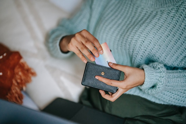A woman putting her credit card inside her wallet to take part in the no spend challenge