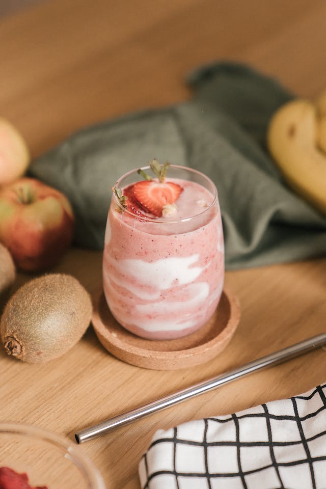 Ben & Jerry's ice cream: A milkshake standing on a coaster surrounded by fruit and napkins