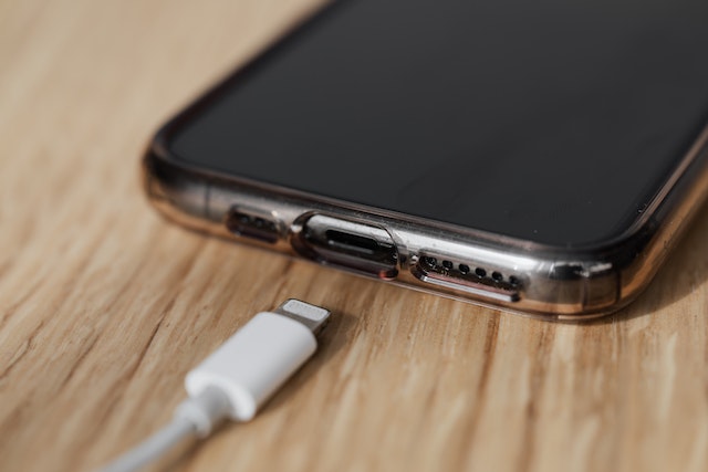 Image: A white USB car phone charger connecting to a smartphone charging port A white USB car phone charger connecting to a smartphone charging port