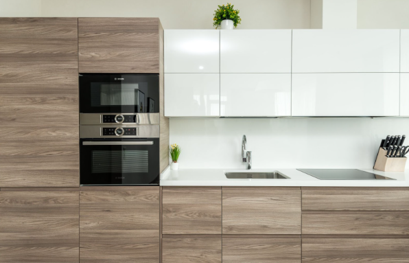 A kitchen with built-in kitchen appliances and a set of knives on the counter.