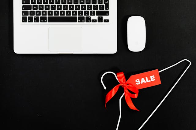 Image: A laptop, mouse and clothes hanger with a tag that says ‘Sale’ A laptop, mouse and clothes hanger with a tag that says ‘Sale’