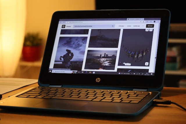Price for an HP laptop: An open black HP laptop displaying pictures on a browser