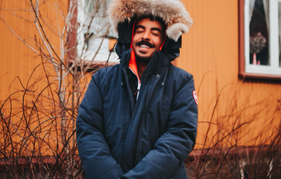 Image: Men’s parka coats with a fur hood: A man wearing a warm coat with a fur hood and smiling because he got a great deal. Men’s parka coats with a fur hood: A man wearing a warm coat with a fur hood and smiling because he got a great deal.