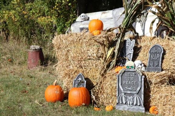 Some of the DIY outdoor Halloween decorations are arranged on hay bales for display