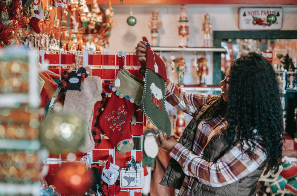 A woman in a store looking at stockings and shopping for kids’ toys for Christmas