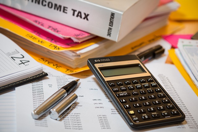 Income tax calculator image with an open diary and lots of paperwork displayed