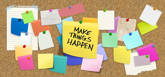 Different coloured sticky papers pinned on a brown vision board