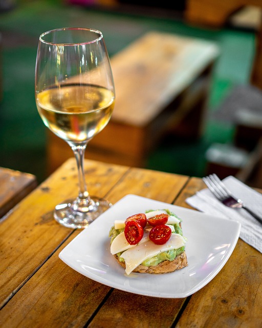 Majestic Wine Club: White wine glass with a tomato and cheese snack on a white side plate.