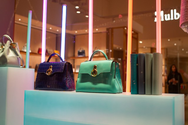 Michael Kors wallet purses: different mini bags and purses displayed on a counter in a variety of colours.