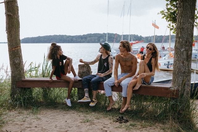 Love Island 2023: Two couples sitting on a wooden bench outside and having fun