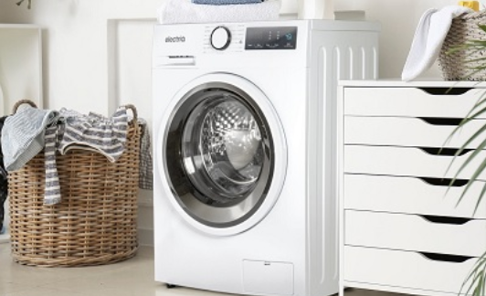 An Appliances Direct washing machine placed inside a laundry room with a laundry basket