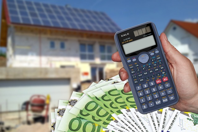 Costs when buying a house: A hand holding a calculator with money at the bottom right and a house in the blurry background.