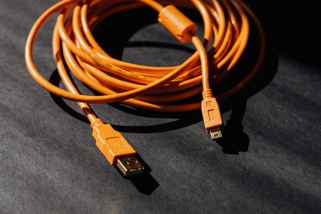 Image: An orange car phone charger USB cable that can be used with a phone holder for the car An orange car phone charger USB cable that can be used with a phone holder for the car