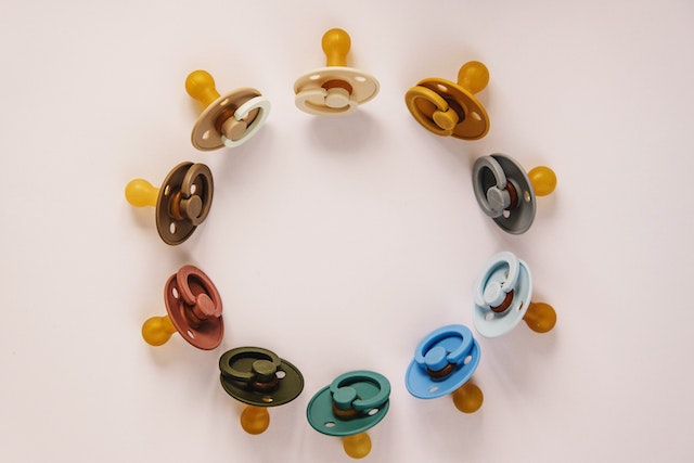 Amazon baby wishlist: Ten pacifiers placed in a circle on a white surface