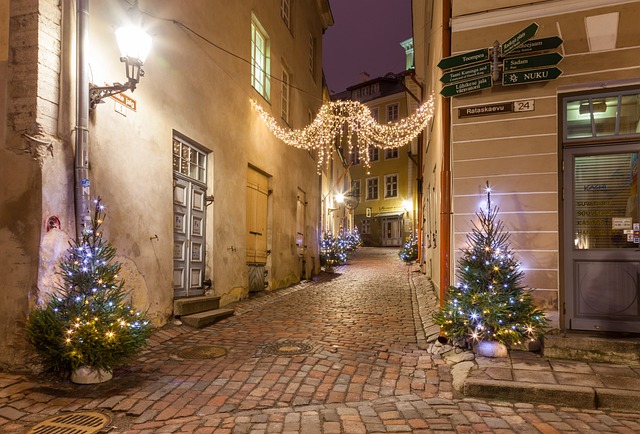 Narrow cobbled street on an evening with decorated Christmas trees and Christmas lighting