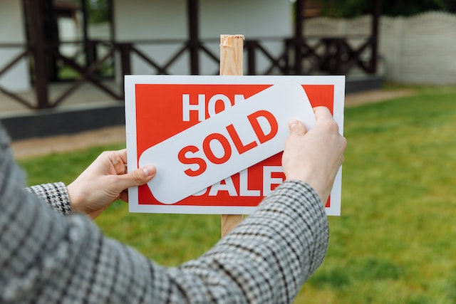 Top 5 property websites: A real estate agent sticking a ‘sold’ sticker on a sign