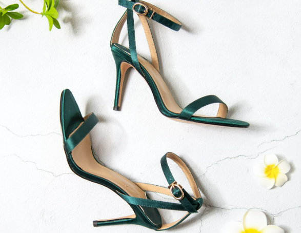A pair of green shoes from the Dorothy Perkins heels range, that is placed next to each other with flowers.