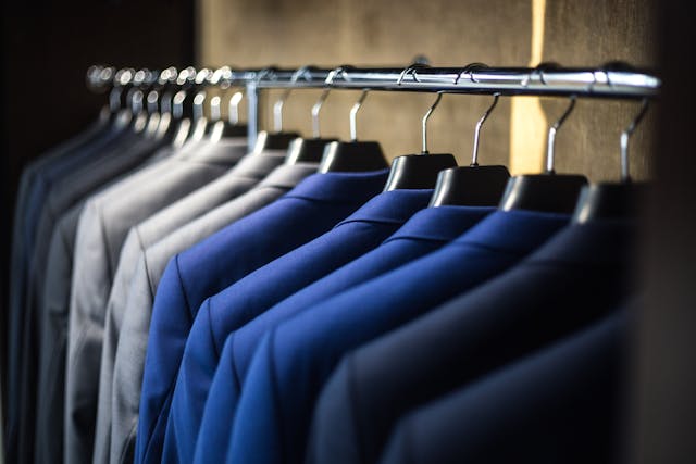 Wedding guest suits: Different suits lined up on a clothing rack