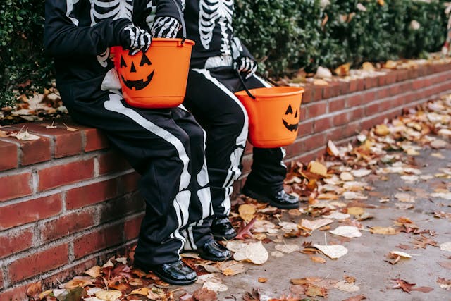 Best Halloween costumes for kids: Two children in Halloween costumes holding candy buckets