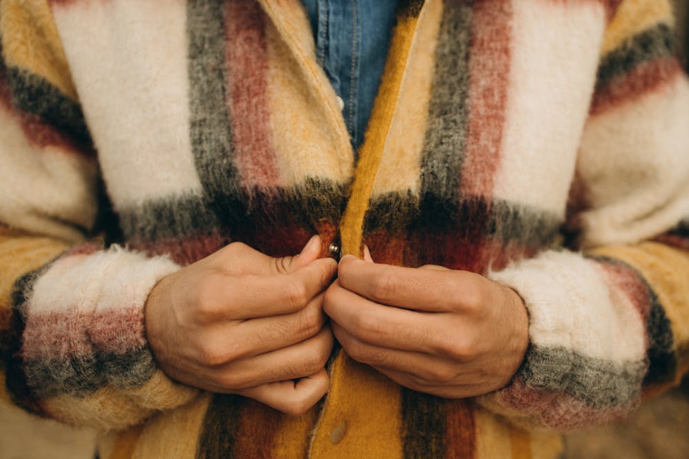 A person buttoning up one of the best jackets for fall and winter