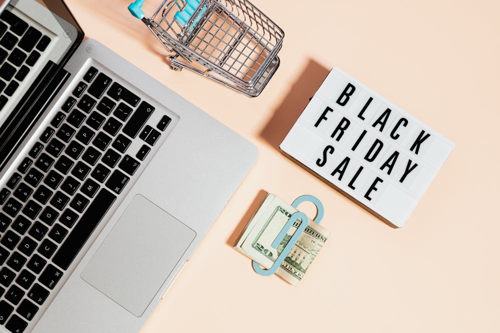 Early online Black Friday deals: A laptop next to a sale sign and money