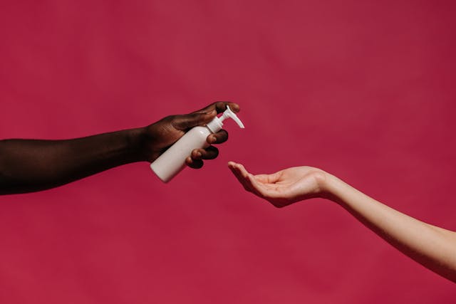 Best hand creams for dry skin: A hand holding out a lotion bottle for another hand