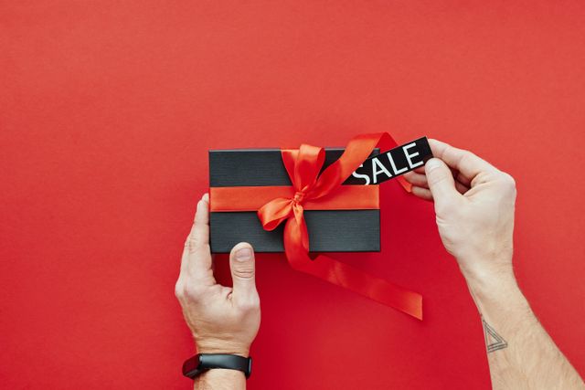 Best Father's Day deals: A person holding a black box with a red ribbon