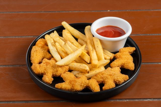 Kids eat for free: A plate of fries, dinosaur chicken nuggets and tomato sauce