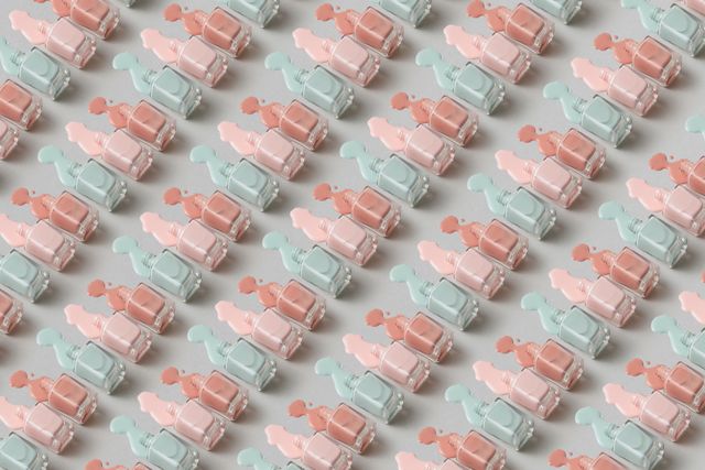 A top view of pastel-coloured nail polish bottles arranged in a repetitive pattern