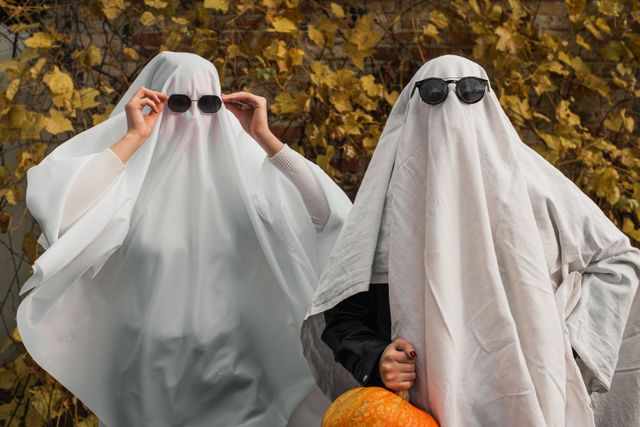 Two people dressed as ghosts wearing easy last-minute Halloween costumes