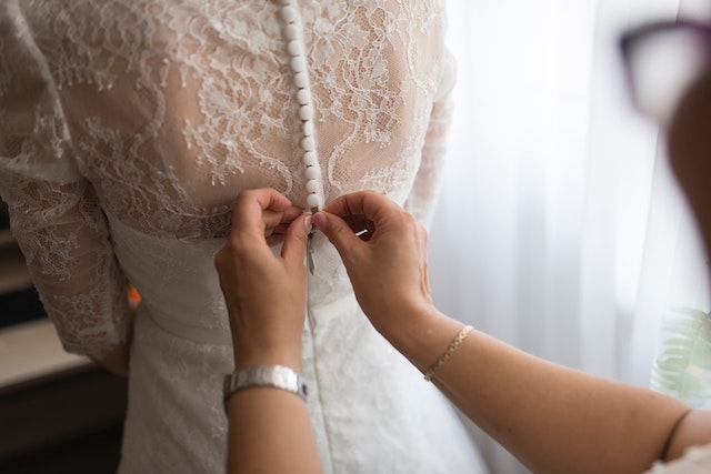 ASOS wedding dresses: A bridesmaid helping the bride fasten her wedding dress