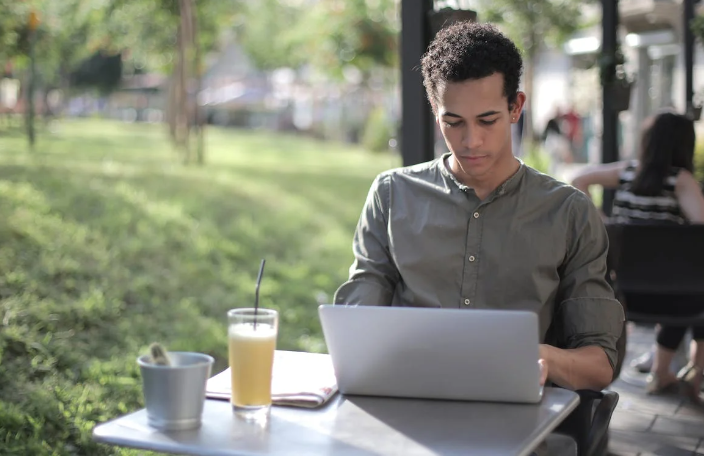 Student at a coffee shop focused on entering the Space NK promo code on his laptop