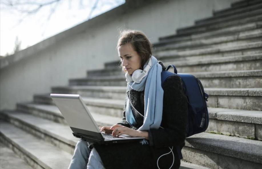 studentessa che cerca un coupon Sports Direct sul suo laptop per risparmiare sull'abbigliamento sportivo