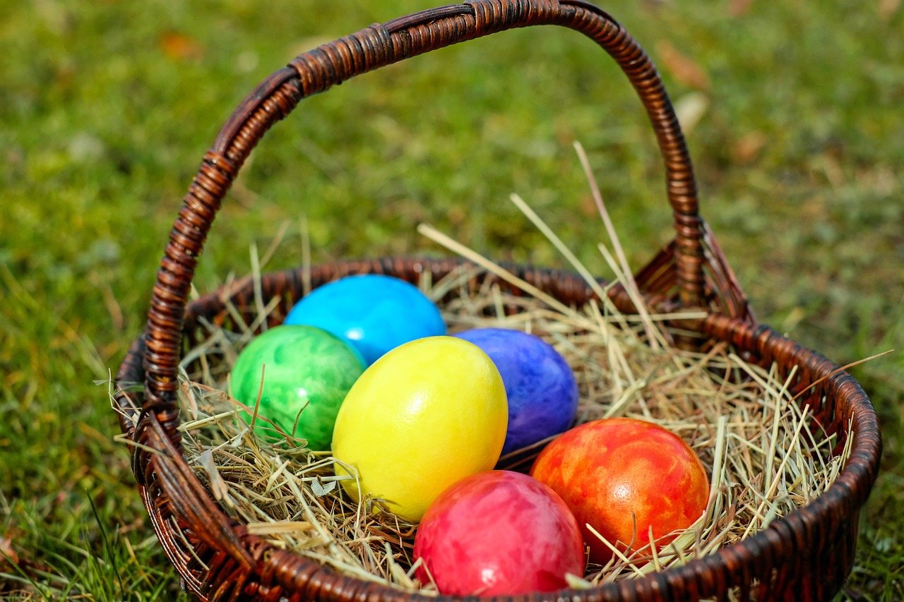 canasta con huevos de pascua de colores en un prado o jardín soleado