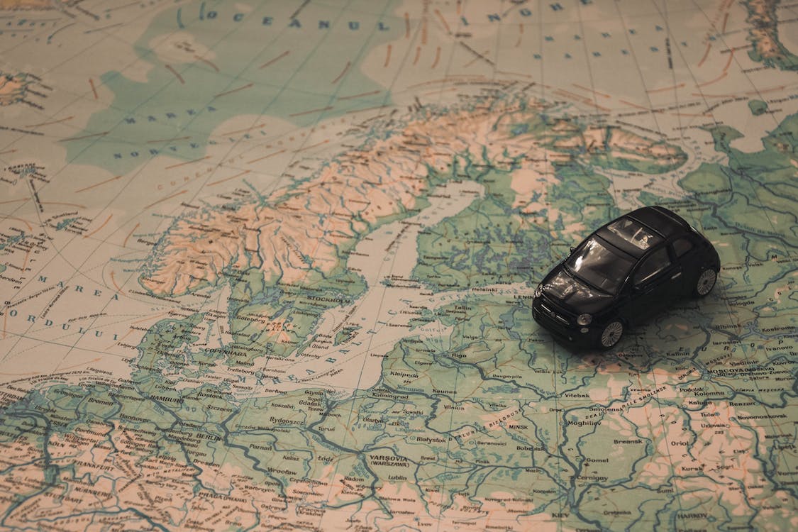 auto su una cartina geografica che indica la possibilità di noleggiare un auto in tutto il mondo, risparmiando grazie ai codici sconto Discover Cars