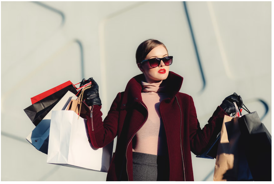 A woman holding several bags of items she bought at ALIGNE
