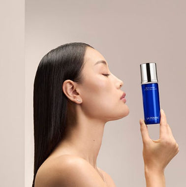 imagen de la web de druni de mujer con un cosmético de druni azúl