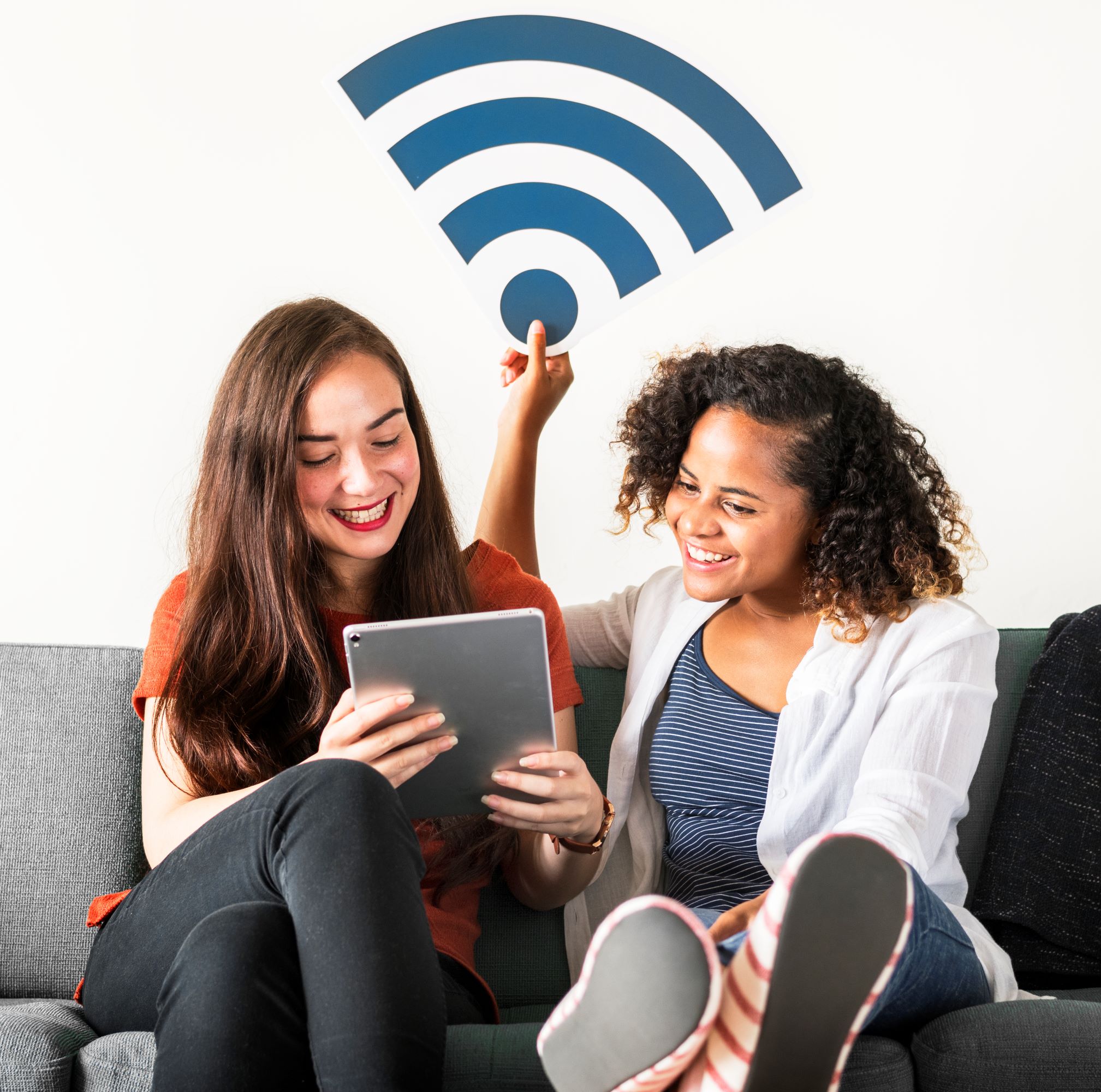 wifi signal on top of two friends viewing a tablet