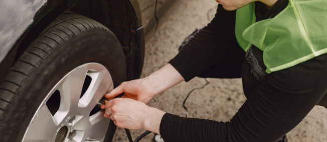 a man refilling a tyre with air for a customer to drive well