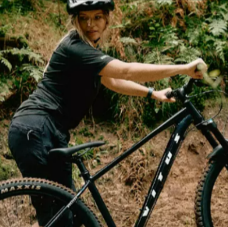 A lady wearing black with a Black Vitus Nucleus 2026 Mountain Bike from Evans Cycles