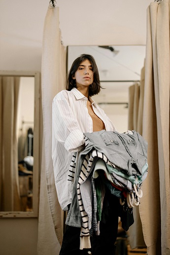 image showing a lady carrying different articles of clothing you can purchase with a COS coupon code