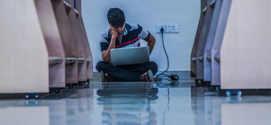 A male student browsing through his laptop for a sale where he will use a Basics Life discount code
