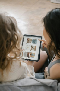 two women looking on their ipdas shopping for new things online