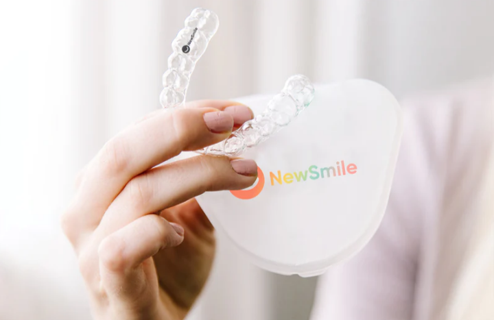 The NewSmile day aligners with their white case that is branded with the NewSmile multi-coloured logo